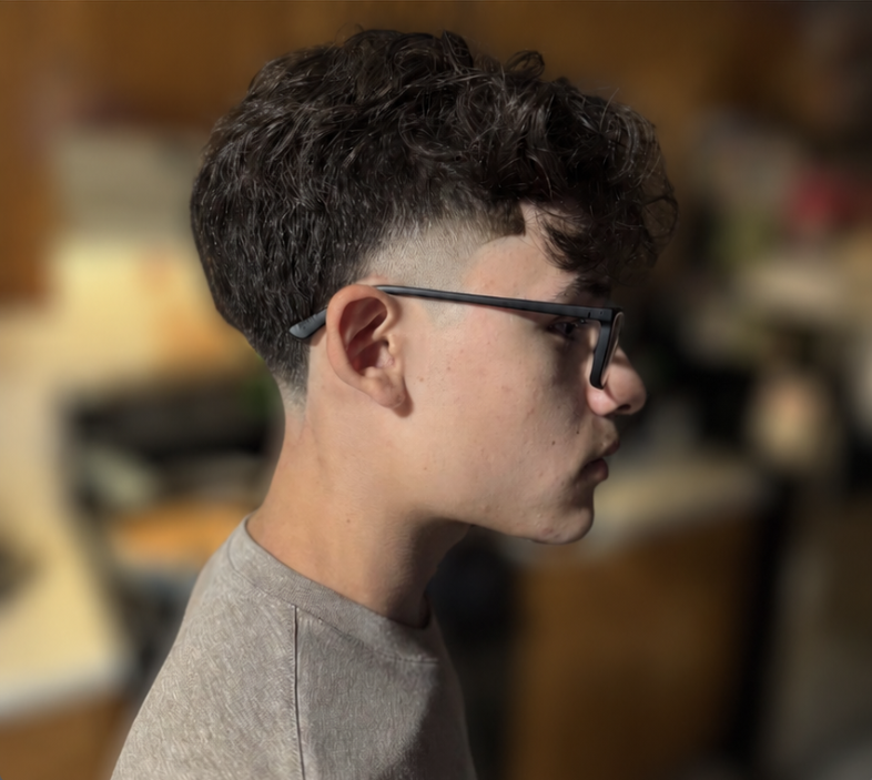 Textured curly top with skin fade haircut by Almighty Cutz By Jesus.